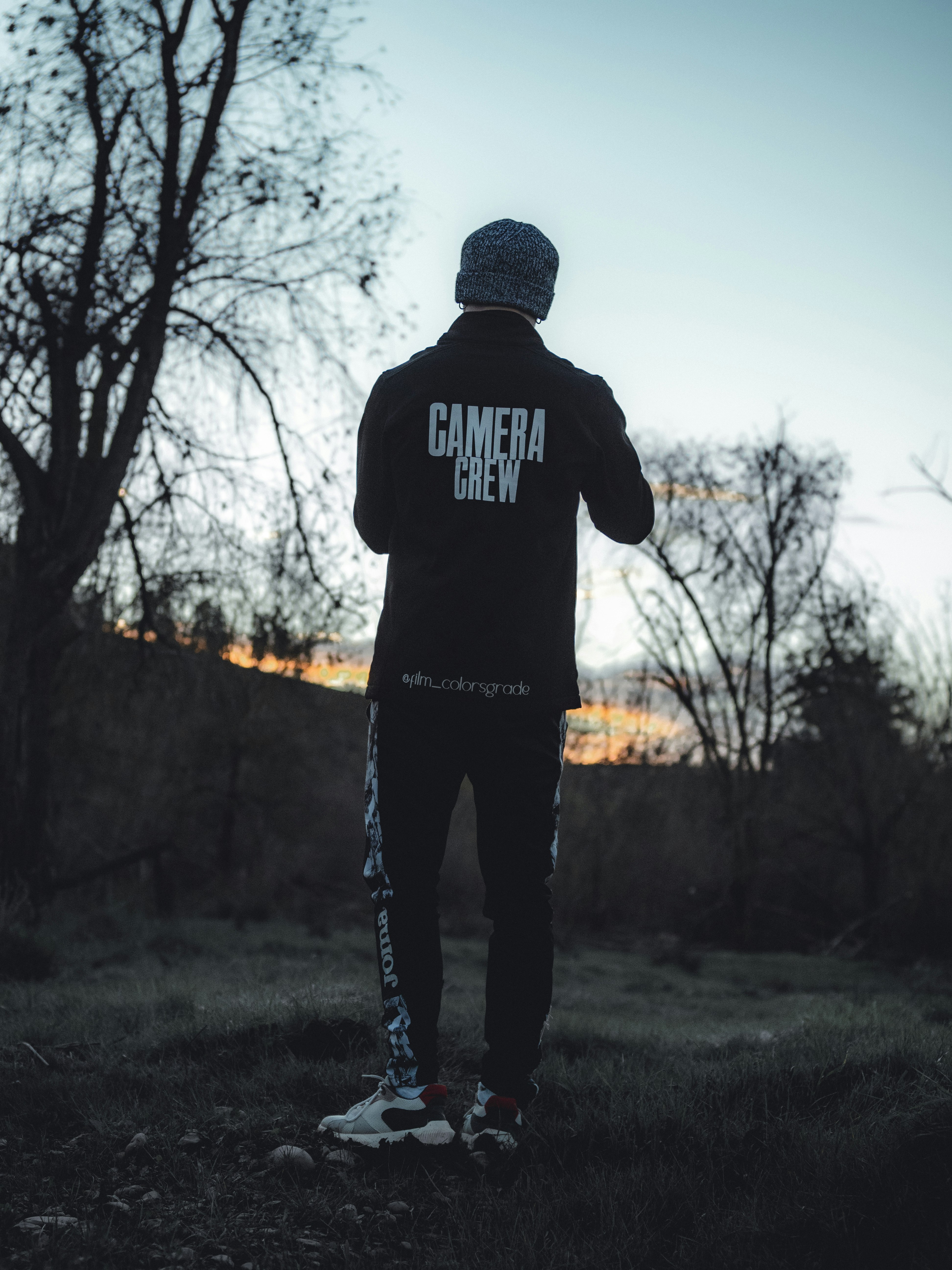 man in black hoodie standing on green grass field during daytime